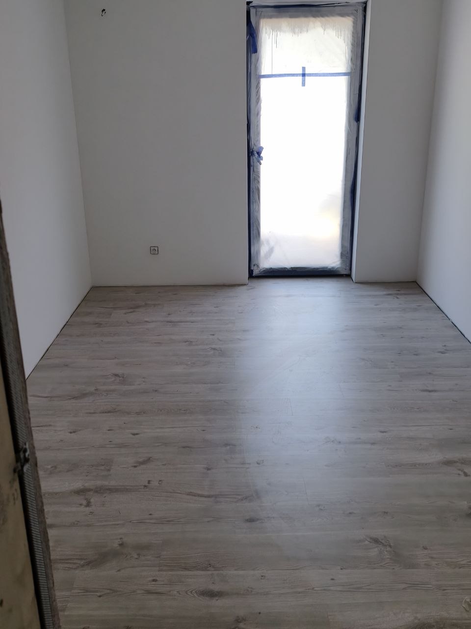 Pokój z położonym laminatem i drzwiami balkonowymi