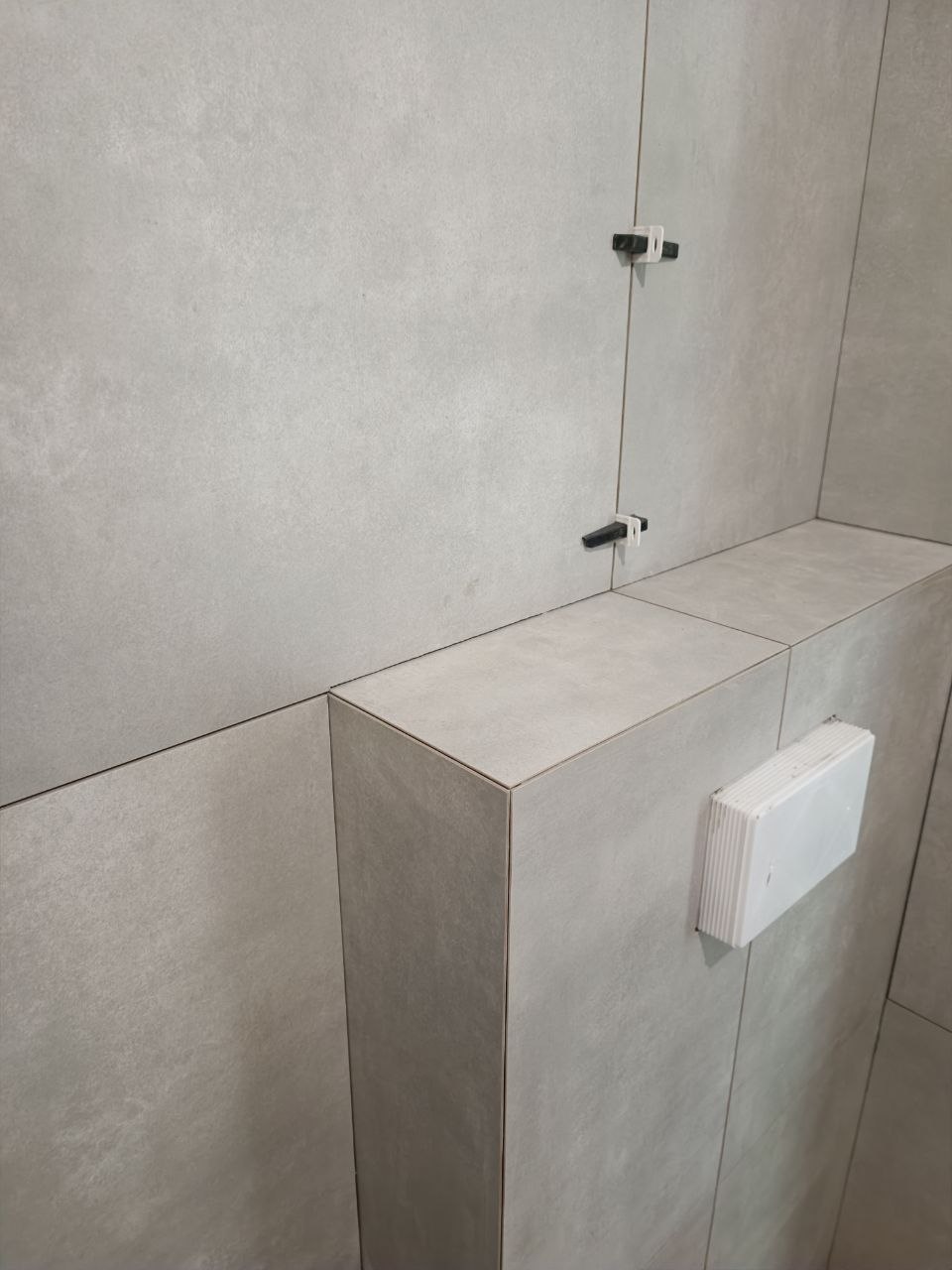 Obudowa stelaża WC wykończona płytkami wielkoformatowymi